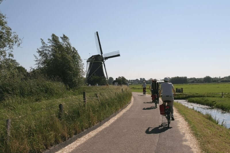 Fietsers bij de molens van de fietstocht het groene hart
